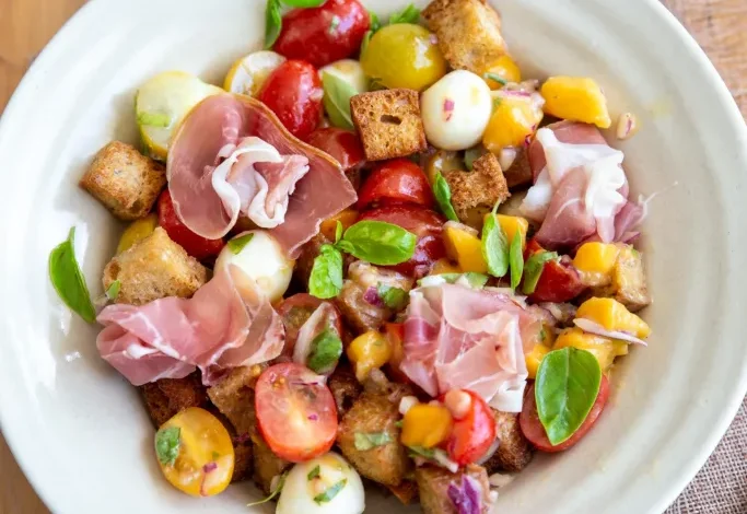 Salade de tomates cerises, croûtons, mangue et mozzarella