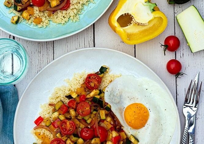 Semoule aux légumes d'été épicés et oeuf sur le plat