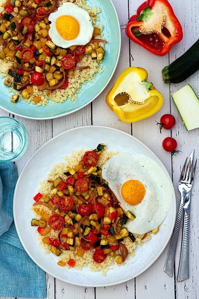 Semoule aux légumes d'été épicés et oeuf sur le plat